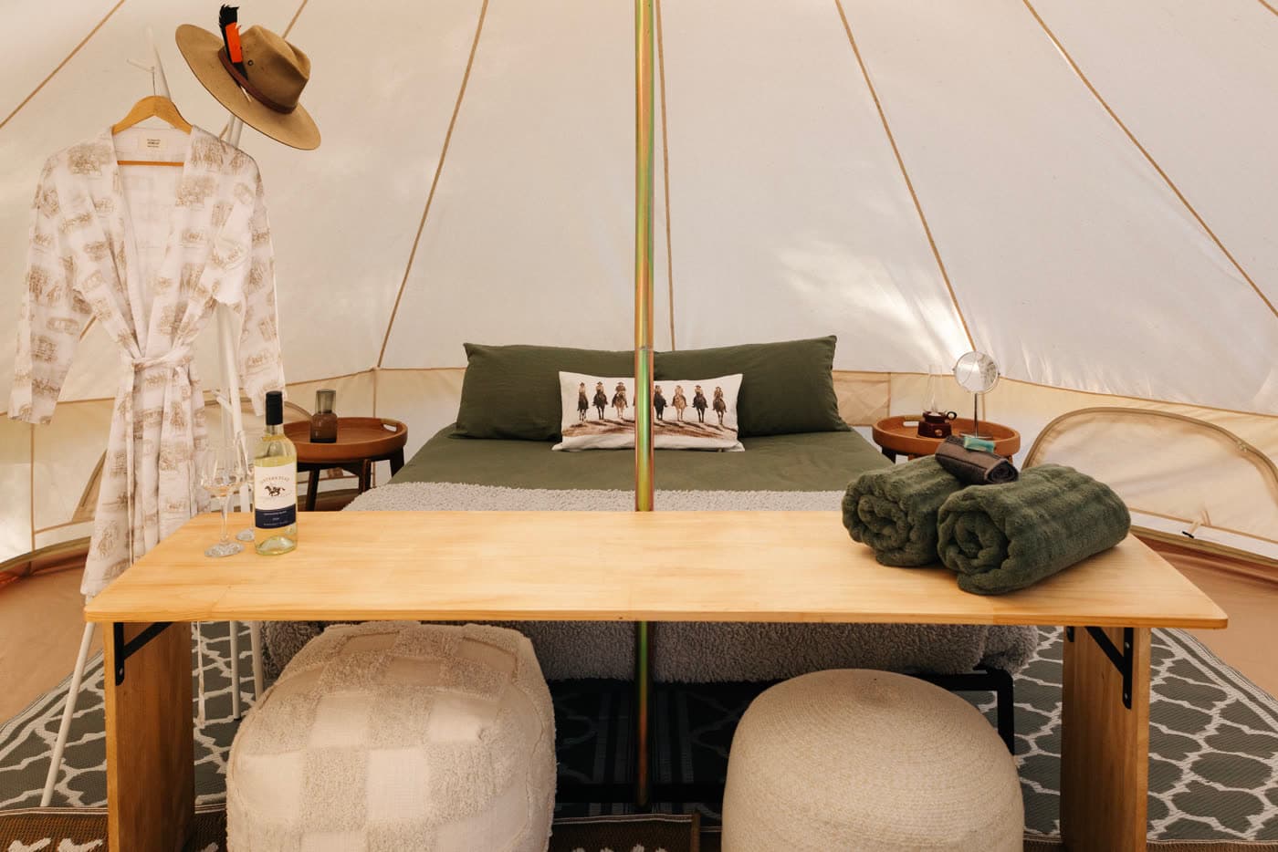 Inside a bell tent set up with a bed, robe and estate wine, Jesters Flat